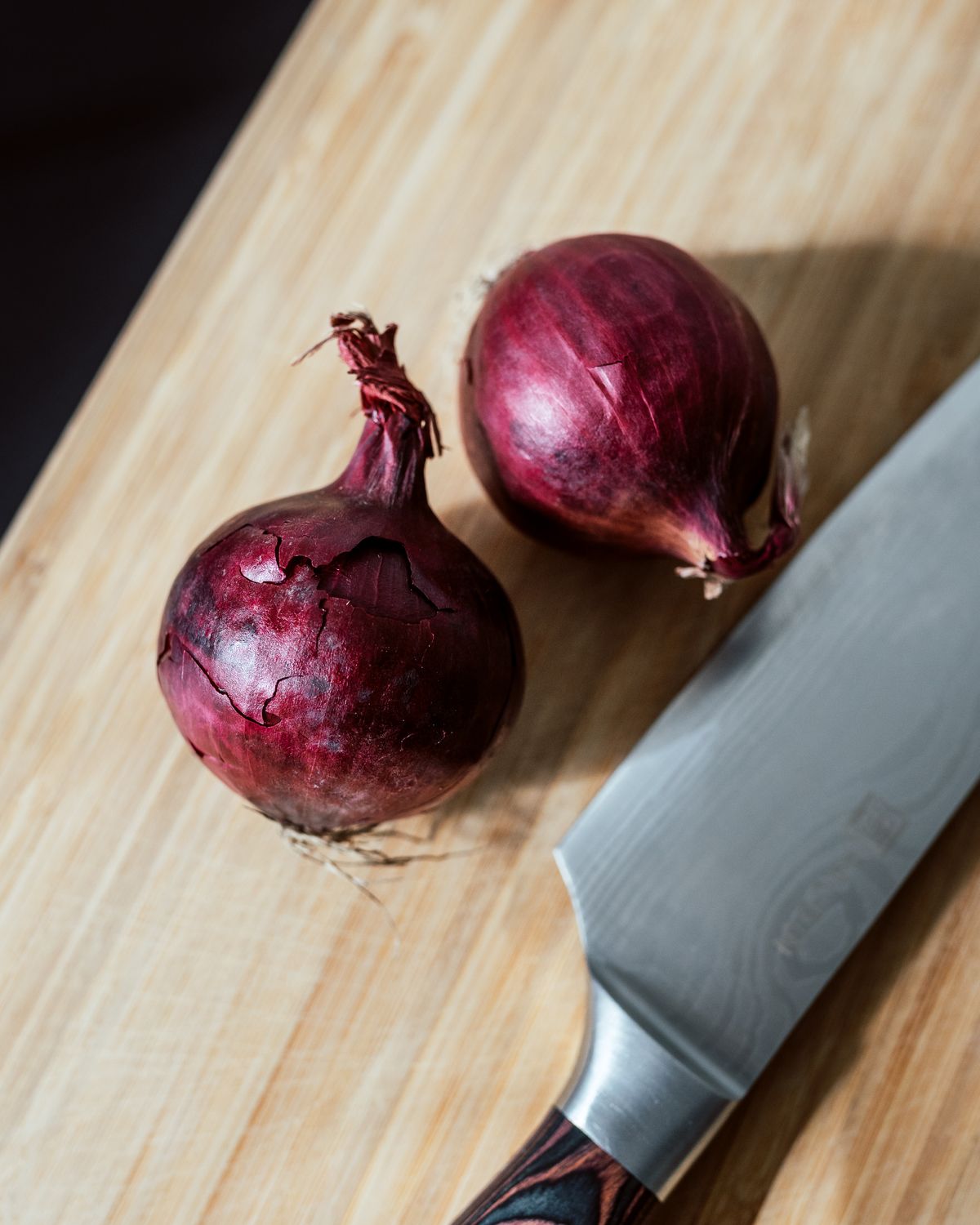 Rote Zwiebeln auf Holzbrett